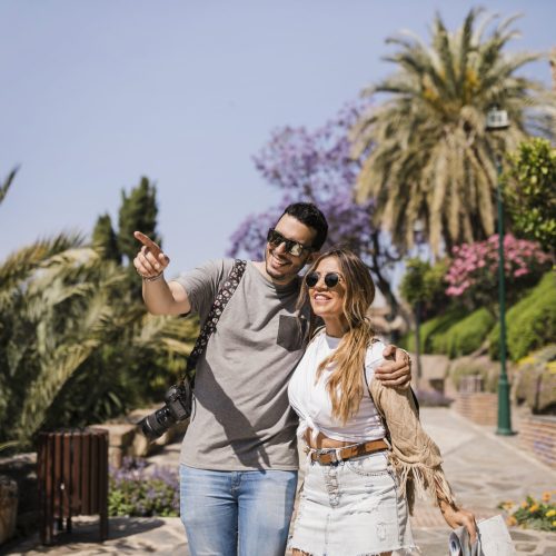 smiling-woman-holding-map-looking-man-pointing-finger